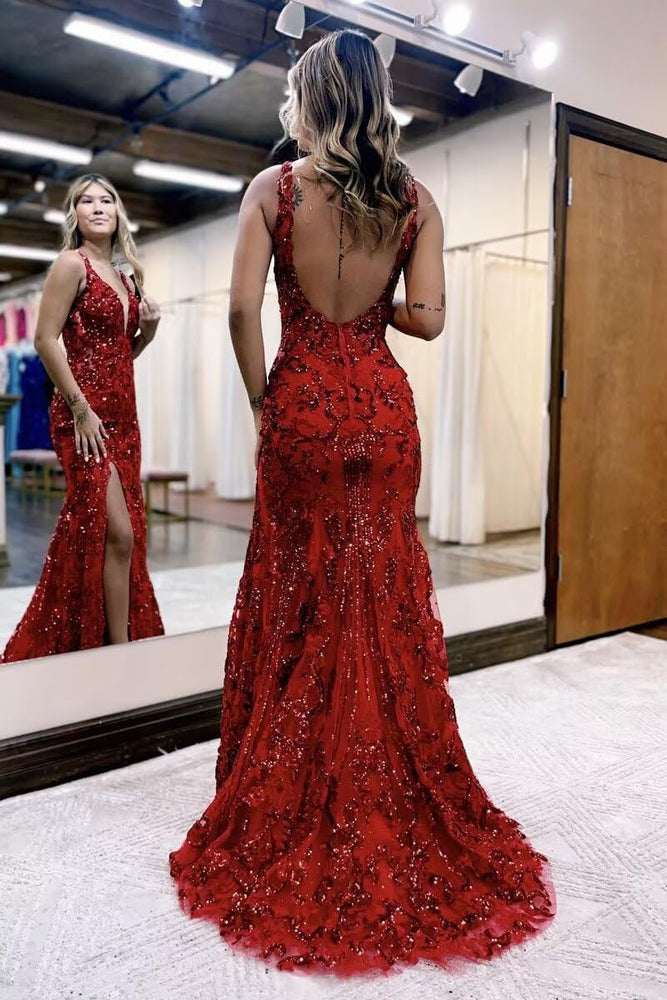 
                  
                    Woman in a red evening gown with a high slit, standing in front of a mirror.
                  
                